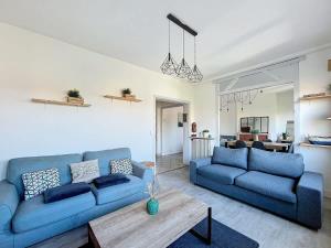 a living room with two blue couches and a table at L'Hyper Centre - Dunkerque in Dunkerque