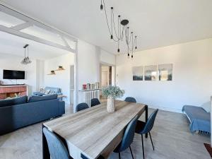 a living room with a wooden table and blue chairs at L'Hyper Centre - Dunkerque in Dunkerque
