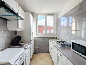 a kitchen with white cabinets and a window at L'Hyper Centre - Dunkerque in Dunkerque