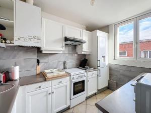 a white kitchen with white cabinets and a sink at L'Hyper Centre - Dunkerque in Dunkerque +2 photos