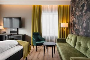 a hotel room with a bed and a couch at Thon Hotel Opera in Oslo