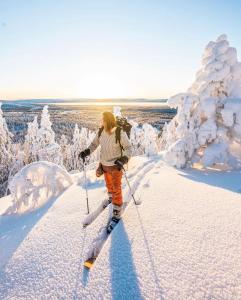 a woman is cross country skiing in the snow at Syöte Igloos in Syöte +22 photos