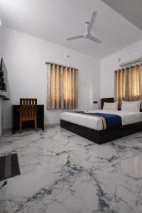 a bedroom with a king sized bed and a chair at Hotel Rhythms Residency in Chennai