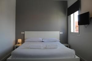 a bedroom with a white bed with two towels on it at Mallorca Rooms Can Pastilla in Can Pastilla