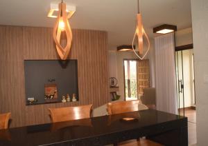 a dining room with a black table and wooden chairs at Suítes e Loft do Tião in Lavras Novas