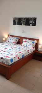 ein Schlafzimmer mit einem Bett mit Holzrahmen und Kissen in der Unterkunft Villa Maheh in Kribi