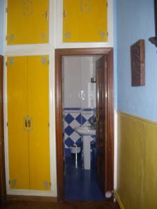 a bathroom with yellow doors and a sink at Hostal Pacios in Madrid