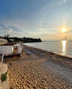 a beach with chaise lounges and a boat at La Praiola in Trappeto