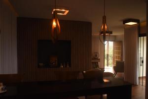 a living room with two lights and a table at Suítes e Loft do Tião in Lavras Novas