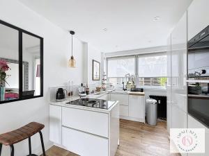 a kitchen with white counters and a large window at L'Atelier Lumière-Centre Ville in Dunkerque
