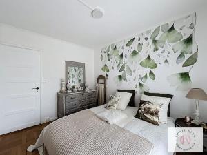 a bedroom with a bed and a wall with leaves at L'Atelier Lumière-Centre Ville in Dunkerque +6 photos