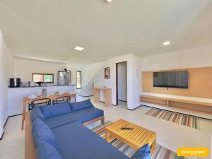 a living room with a blue couch and a tv at Beachfront Duplex B por Be My Guest in Aquiraz