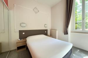 a white bed in a room with a window at Logis Hotel restaurant des Thermes in Lamalou-les-Bains +37 photos