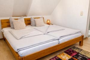 a bed with white sheets and pillows in a room at Hotel zum Rednitzgrund in Stein