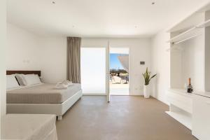 a white bedroom with a bed and a balcony at Agriturismo Agricola Chiani in Melendugno