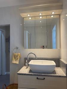 a bathroom with a sink and a large mirror at Picasso's Cottage in Gqeberha +11 photos