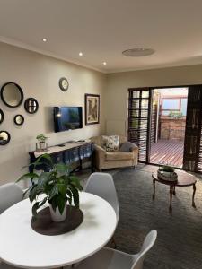 a living room with a couch and a table at Picasso's Cottage in Gqeberha