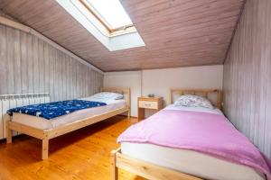 a bedroom with two beds and a skylight at Apartmaji Loretica in Most na Soči