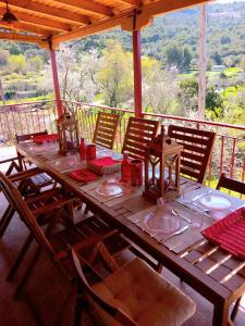 a wooden table with chairs on a porch with a view at Alma-Maroon Klara & Rachel in Drymon