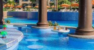 a pool with blue water with tables and umbrellas at Pueblo Bonito Sunset Beach Owners Exec Suite 1BR2B REQUEST DATE see Clay & Lisa in Cabo San Lucas