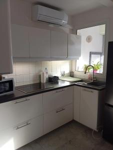 a white kitchen with white cabinets and a window at Monplaisir in Fréjus