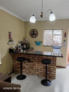 a kitchen with a bar with two stools at Habakkuk Guesthouse in Bethlehem