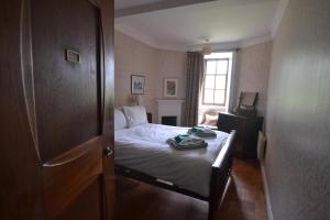 a small bedroom with a bed and a window at Butlers Quarters Apartment in Cairndow +11 photos