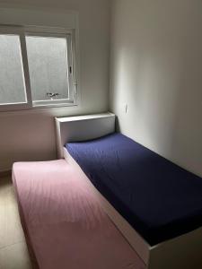 a bed in a room with a window at Refúgio Rossa in Xangri-lá