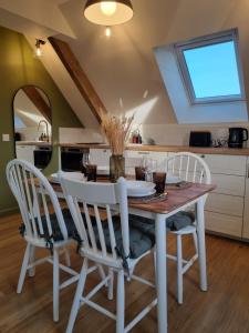 a kitchen with a dining room table and chairs at Le perchoir de Pibri - Les apparts de Maddy in Meyssac