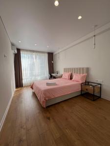 a bedroom with a large bed with pink pillows at Cruds Arena Chisinau in Chişinău