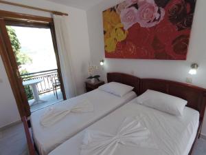 two beds in a room with a window at Poseidon Studios in Kokkari