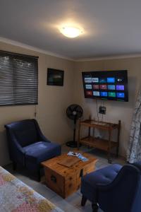 a living room with two chairs and a tv at Blue Sky Retreat in Vredenburg