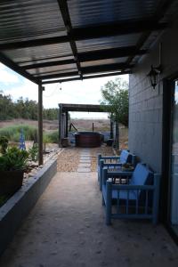 a patio with blue chairs and a hot tub at Blue Sky Retreat in Vredenburg