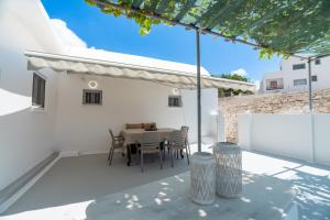 a dining area with a table and chairs on a patio at Earthy House in Mesaria