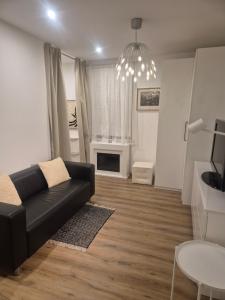 a living room with a black couch and a table at Dein Zuhause am See in Millstatt