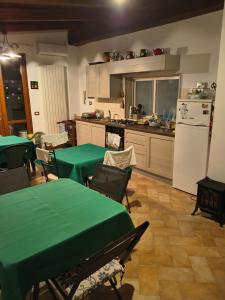 a kitchen with green tables and a white refrigerator at villa marta in Formia