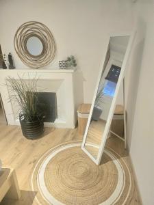 a living room with a mirror and a fireplace at La petite maison dans la bastide in Carcassonne