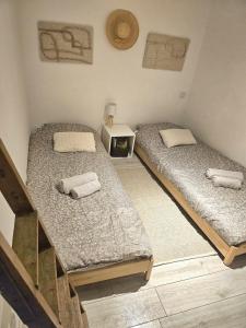 two twin beds in a room with a table at La petite maison dans la bastide in Carcassonne