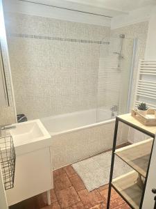 a white bathroom with a tub and a sink at La petite maison dans la bastide in Carcassonne +5 photos