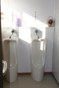 - une salle de bains avec deux urinoirs blancs dans une chambre dans l'établissement Drive Inn Keigetsu, à Towada