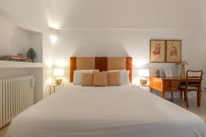a bedroom with a large white bed and a desk at Dimora Lùmina in Gallipoli
