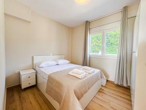 a small bedroom with a bed and a window at Seaside Pool Villas by BookVillaEU in Nea Kallikrateia +49 photos