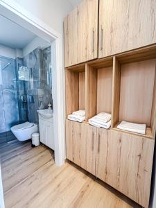 a bathroom with a large wooden cabinet in a room at Seaside Pool Villas by BookVillaEU in Nea Kallikrateia