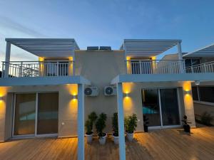 a house with a deck with potted plants on it at Seaside Pool Villas by BookVillaEU in Nea Kallikrateia