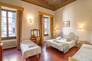 a hotel room with two beds and a window at Hotel Cimabue in Florence
