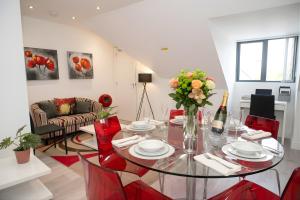 a living room with a glass table and red chairs at Rosey Lodge -1Bedroom Cousy Flat - Parking, Netflix, WIFI - Close to Blenheim Palace & Oxford - F5 in Oxford