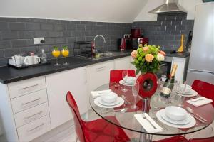 a kitchen with a glass table and red chairs at Rosey Lodge -1Bedroom Cousy Flat - Parking, Netflix, WIFI - Close to Blenheim Palace & Oxford - F5 in Oxford +12 photos