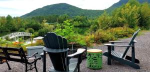 a group of chairs sitting in front of a lake at Lakeside Gateway 4 Spa Sauna Firepit in Sainte Brigitte de Laval