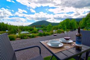 a table with a bottle of wine and two glasses at Lakeside Gateway 4 Spa Sauna Firepit in Sainte Brigitte de Laval