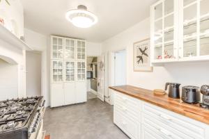 a kitchen with white cabinets and a stove at Host & Stay - Combpyne in Compton